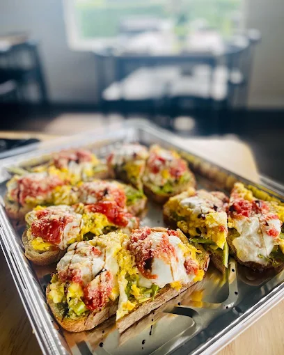 A catering tray of avocado toasts topped with eggs