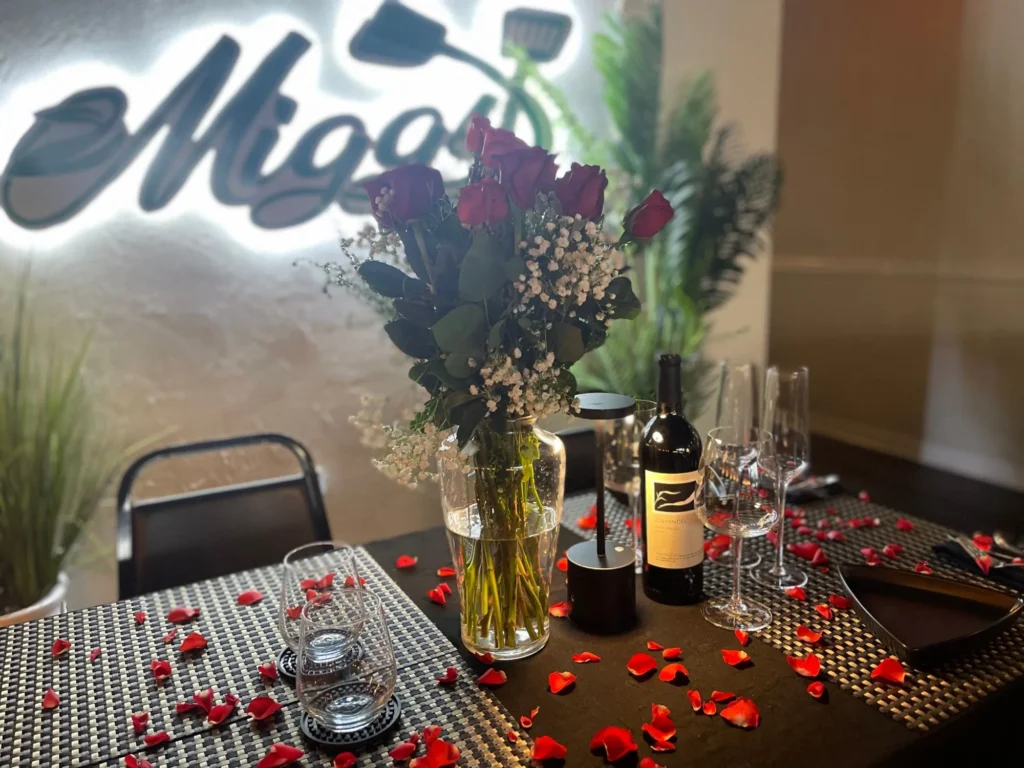 A table set for date night with roses and red wine