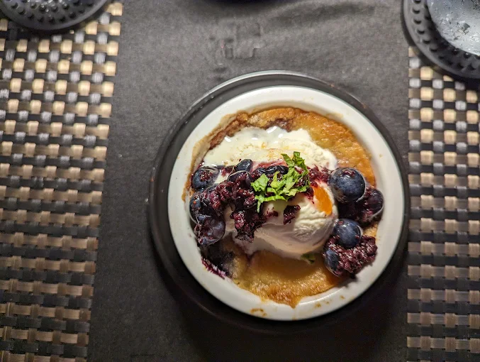 A warm dessert with vanilla ice cream and blueberries