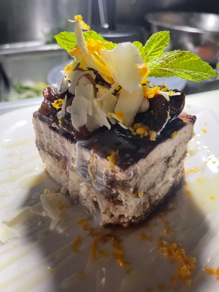 A layered chocolate dessert with white chocolate, orange zest and mint