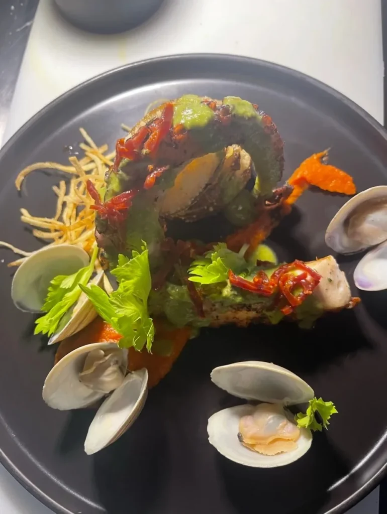 Grilled octopus with clams, romesco and green herb sauce